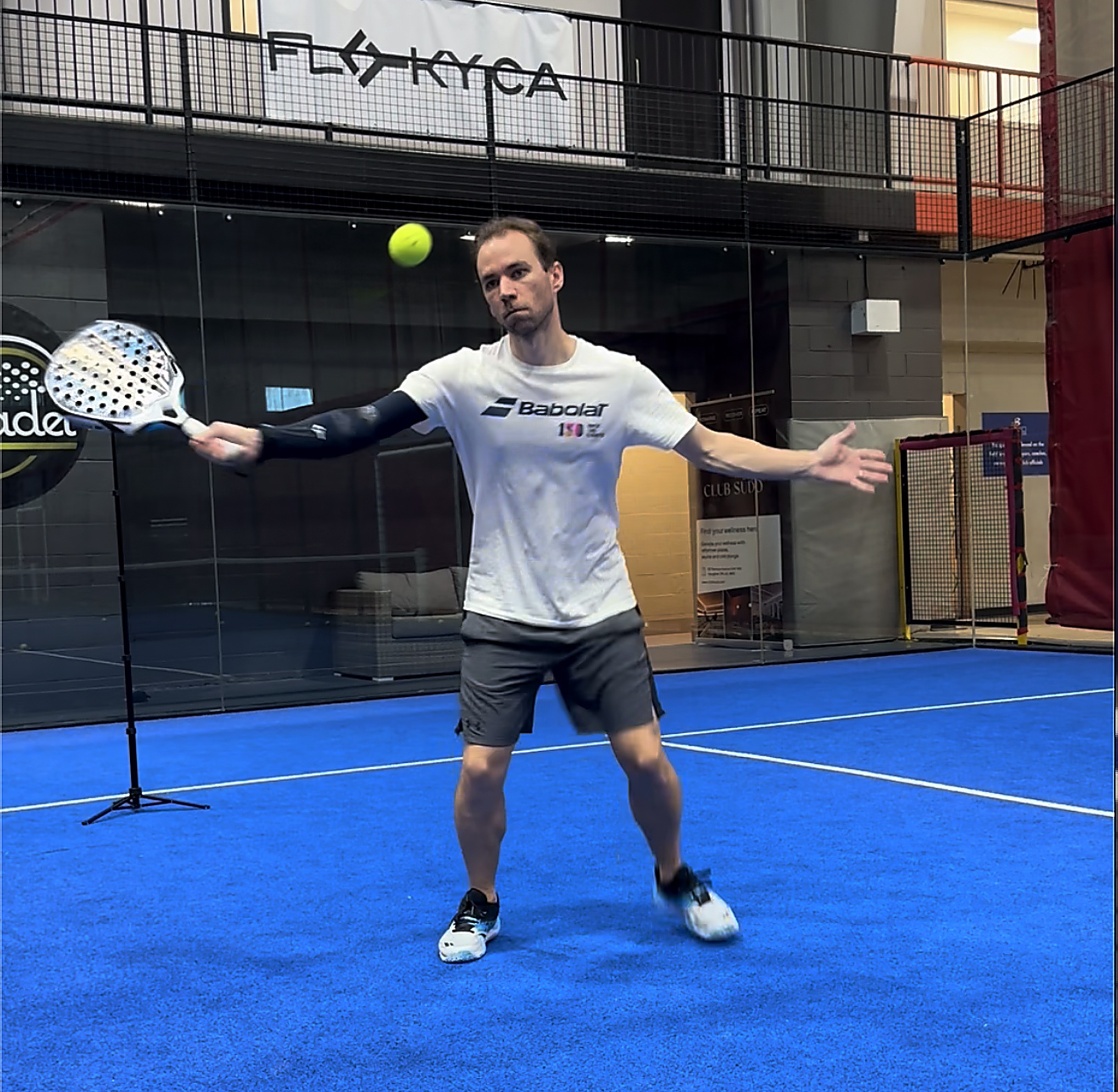 Leo preparing a volley on a blue padel court.